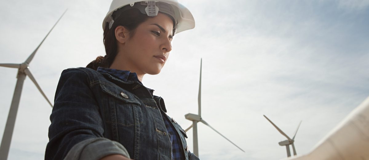 Female engineer at wind farm with plans