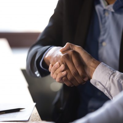 Close up african american businessman shaking hands with caucasian client. Handshake is symbol of starting finishing negotiations, successful teamwork signing contract, hiring human resource concept